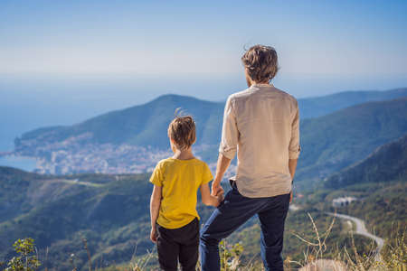 Happy family on the background of Panoramic view of the city of Budva, Montenegro. Beautiful view from the mountains to the Adriatic Seaの写真素材