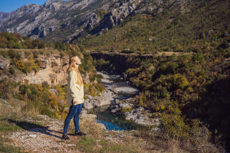 Montenegro. Woman tourist on the background of Clean clear turquoise water of river Moraca in green moraca canyon nature landscape. Travel around Montenegro conceptの写真素材