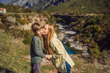 Montenegro. Mom and son tourists on the background of Clean clear turquoise water of river Moraca in green moraca canyon nature landscape. Travel around Montenegro conceptの写真素材