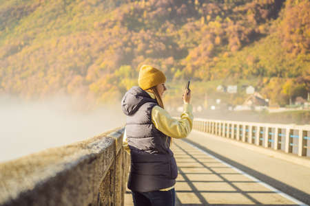 Montenegro. Woman touriste in background of Dzhurdzhevich Bridge Over The River Tara foggy morning....