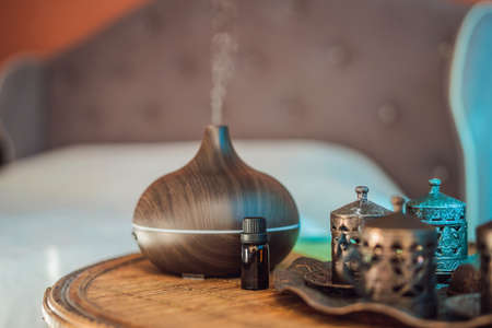 Aroma oil diffuser with aroma oil on table at home. Air freshenerの写真素材