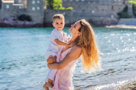 Mother and son tourists on background of beautiful view St. Stephen island, Sveti Stefan on the Budva Riviera, Budva, Montenegro. Travel to Montenegro conceptの写真素材