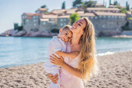 Mother and son tourists on background of beautiful view St. Stephen island, Sveti Stefan on the Budva Riviera, Budva, Montenegro. Travel to Montenegro conceptの写真素材
