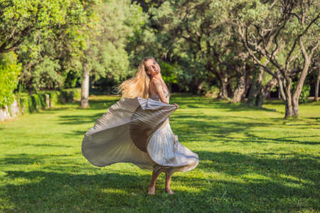 Woman tourist walking in Montenegro. Panoramic summer landscape of the beautiful green Royal park Milocer on the shore of the the Adriatic Sea, Montenegroの写真素材