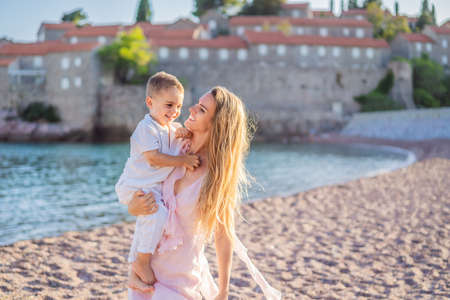 Mother and son tourists on background of beautiful view St. Stephen island, Sveti Stefan on the Budva Riviera, Budva, Montenegro. Travel to Montenegro conceptの写真素材