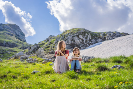 Family of tourists mom and son in Mountain lake landscape on Durmitor mountain in Montenegro beautiful Durmitor National park with lake glacier and reflecting mountainの写真素材