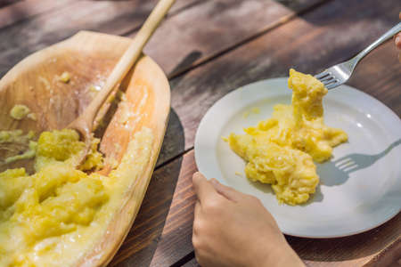Traditional Montenegrin Meal. Kacamak in wooden bowl in the outdoor cafeの写真素材