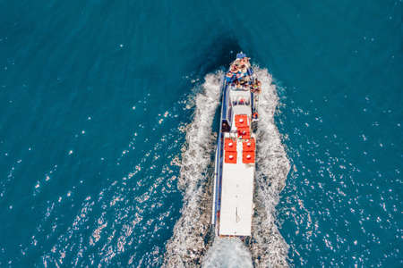 Ferry boat with tourists on the move on floats on turquoise water. Drone viewの写真素材