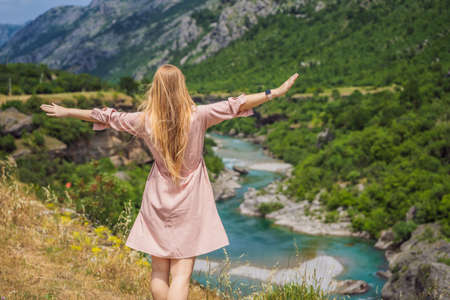 Woman tourist on background of purest waters of the turquoise color of the river Moraca flowing among the canyons. Travel around Montenegro conceptの写真素材