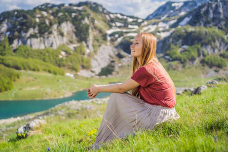 Woman tourist in Mountain lake landscape on Durmitor mountain in Montenegro beautiful Durmitor National park with lake glacier and reflecting mountainの写真素材