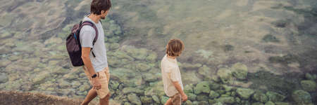 Dad and son tourists walks along the coast of Budva in Montenegro BANNER, LONG FORMAT