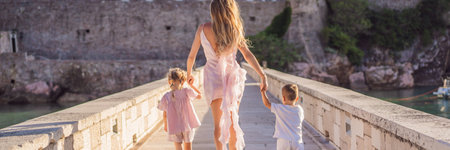BANNER, LONG FORMAT Mother and two children daughter and son tourists on background of beautiful view St. Stephen island, Sveti Stefan on the Budva Riviera, Budva, Montenegro. Travel to Montenegro concept.の写真素材