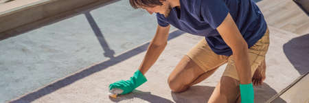 Man cleaning the carpet with foam on the balcony BANNER, LONG FORMAT