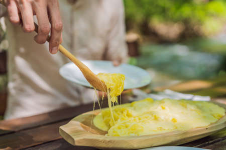 Male tourist eating Traditional Montenegrin Meal. Kacamak in wooden bowl in the outdoor cafe Portrait of a disgruntled girl sitting at a cafe tableの写真素材