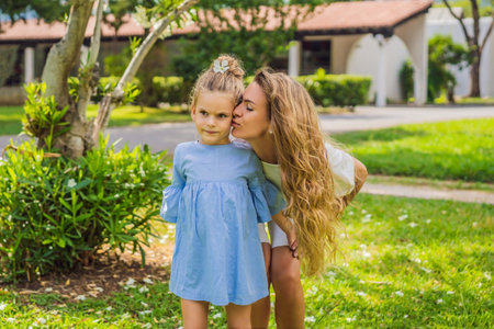 young pretty mother walking with little cute daughter outside in green park, lifestyle poeple concept Portrait of a disgruntled girl sitting at a cafe tableの写真素材