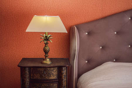 Bright eco light in the corner of a modern bedroom. New led technology meets traditional interior design. Lamp is creating cozy atmosphere in room. Wooden, glass table, blue curtainsの写真素材