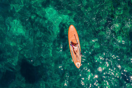Young women Having Fun Stand Up Paddling in blue water sea in Montenegro. SUP. girl Training on Paddle Board near the rocks Portrait of a disgruntled girl sitting at a cafe tableの写真素材