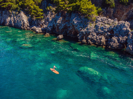 Young women Having Fun Stand Up Paddling in blue water sea in Montenegro. SUP. girl Training on Paddle Board near the rocks Portrait of a disgruntled girl sitting at a cafe tableの写真素材