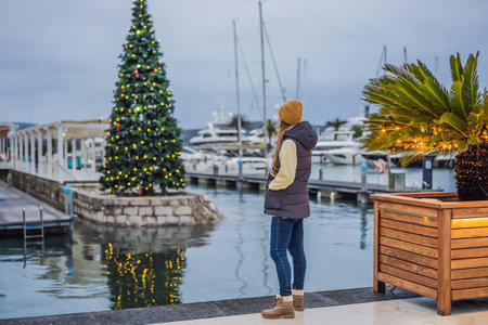Woman on the background of the Christmas tree. Christmas in the port. Montenegro, Porto Montenegroの写真素材
