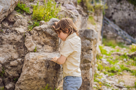 Boy tourist walks through the old town of Bar in Montenegro. Happy tourist walks in the mountains. Suburbs of the city of Bar, Montenegro, Balkans. Beautiful nature and landscapeの写真素材