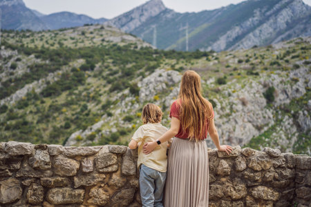 Mom and son tourists walks through the old town of Bar in Montenegro. Happy tourist walks in the mountains. Suburbs of the city of Bar, Montenegro, Balkans. Beautiful nature and landscapeの写真素材