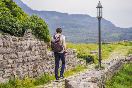 Man tourist walks through the old town of Bar in Montenegro. Happy tourist walks in the mountains. Suburbs of the city of Bar, Montenegro, Balkans. Beautiful nature and landscapeの写真素材
