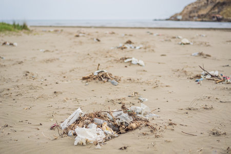 Spilled garbage on the beach. Empty used dirty plastic bottles. Environmental pollution. Ecological problemの写真素材