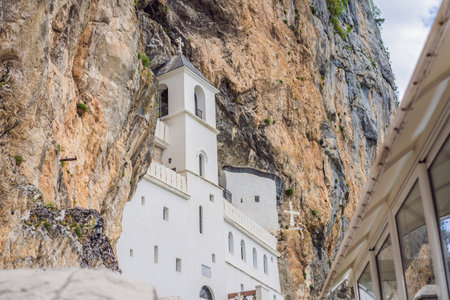 Monastery of Ostrog, Serbian Orthodox Church situated against a vertical background, high up in the large rock of Ostroska Greda, Montenegro. Dedicated to Saint Basil of Ostrogの写真素材