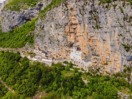 Monastery of Ostrog, Serbian Orthodox Church situated against a vertical background, high up in the large rock of Ostroska Greda, Montenegro. Dedicated to Saint Basil of Ostrogの写真素材