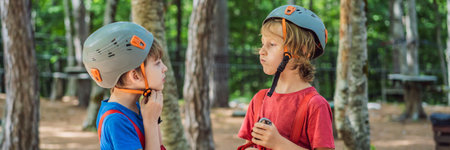 BANNER, LONG FORMAT Friends on the ropes course. Young people in safety equipment are obstacles on...