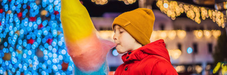 BANNER, LONG FORMAT Boy with cotton candy at christmas market. Happy child on Christmas market. Traditional leisure for families on xmasの写真素材