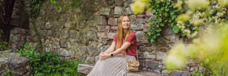BANNER, LONG FORMAT Woman tourist walks through the old town of Bar in Montenegro. Happy tourist walks in the mountains. Suburbs of the city of Bar, Montenegro, Balkans. Beautiful nature and landscapeの写真素材