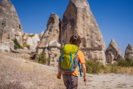 Boy tourist on background of Unique geological formations in Love Valley in Cappadocia, popular travel destination in Turkey. Traveling with children in Turkey conceptの写真素材