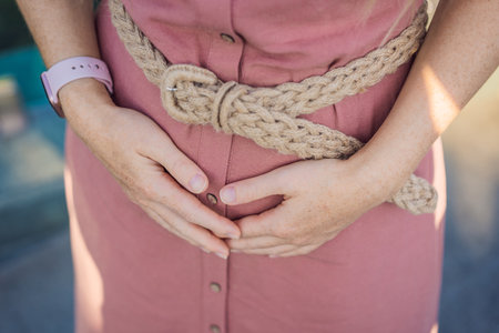 pregnant belly 1st trimester. Happy pregnant woman holding her belly in the 1st month of pregnancy. Pregnancy, future mom, changing body and happiness conceptの写真素材