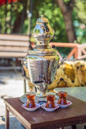 Drinking Traditional Turkish Tea with Turkish tea cup and copper tea potの写真素材