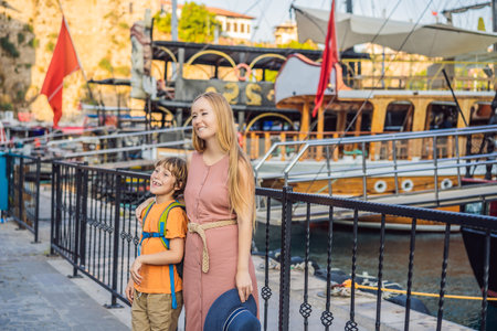 Mom and son tourists in Old town Kaleici in Antalya. Turkiye. Panoramic view of Antalya Old Town port, Taurus mountains and Mediterrranean Sea, Turkey. Traveling with kids conceptの写真素材