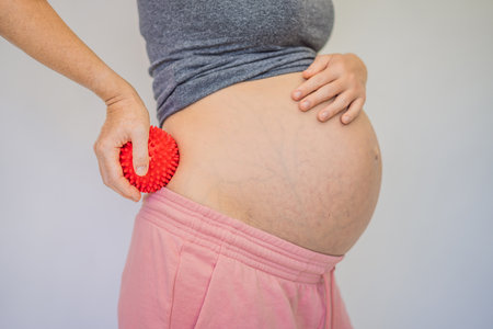 Self-massage with a massager for a pregnant womanの写真素材