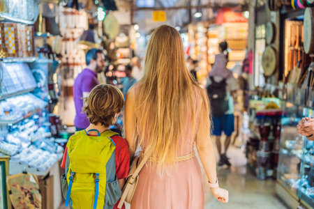 mother and son tourists walks among the countless shops at the Grand Bazaar and Egyptian Bazaar in Istanbul. Shopping and travel in Turkey concept. Istanbul historical Egyptian Bazaar. Misir Carsisi, spice market. Turkiyeの写真素材