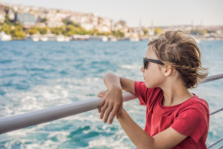 Happy boy enjoying the sea from ferry boat crossing Bosphorus in Istanbul. Summer trip to Istanbul. Traveling with kids conceptの写真素材
