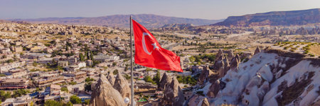 BANNER, LONG FORMAT Turkish flag on the hill with typical tuff rock formations of the Cappadocia against the backdrop of a blue sky, Goreme, Turkeyの写真素材