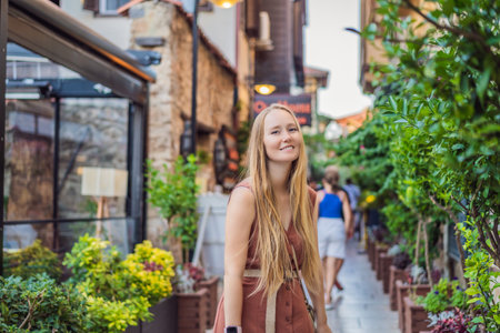 Happy woman tourist on background of old street of Antalya. female tourist traveler discover interesting places and popular attractions and walks in the old city Kalechi of Antalya, Turkey. Turkiyeの写真素材