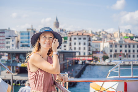 Happy woman enjoying the sea from ferry boat crossing Bosphorus in Istanbul. Summer trip to Istanbulの写真素材