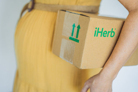12.16.22, USA, Miami: A pregnant woman received an iherb package. Vitamins and minerals for a healthy pregnancy at iherbのeditorial素材