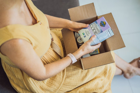 12.16.22, USA, Miami: A pregnant woman received an iherb package. garden of life, vitamin code raw prenatal. Vitamins and minerals for a healthy pregnancy at iherbのeditorial素材