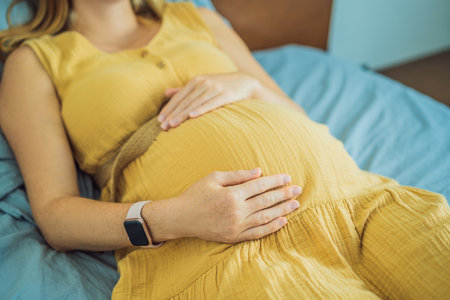 A stressed tired pregnant mother lying in bed at home. Morning sickness and nausea