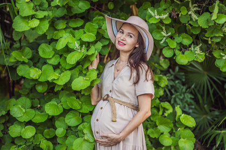 A serene and radiant pregnant woman after 40, surrounded by natures beauty in the park, cherishing...