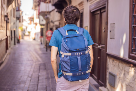 Happy man tourist on background of old street of Antalya. male tourist traveler discover interesting places and popular attractions and walks in the old city Kalechi of Antalya, Turkey. Turkiyeの写真素材