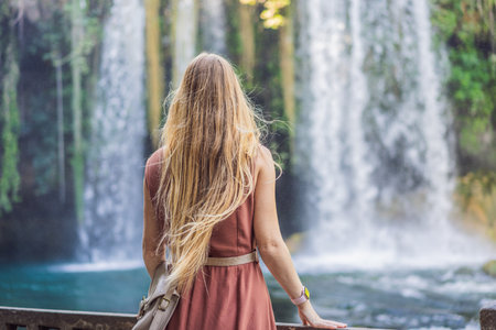 Beautiful woman with long hair on the background of Duden waterfall in Antalya. Famous places of Turkey. Apper Duden Fallsの写真素材
