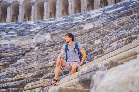 Man tourist explores Aspendos Ancient City. Aspendos acropolis city ruins, cisterns, aqueducts and old temple. Aspendos Antalya Turkey. turkiyeの写真素材