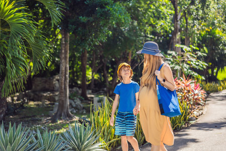 Expectant mother and her son enjoying a leisurely stroll in the park, cherishing precious moments amidst natures beautyの写真素材